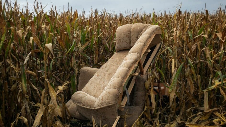 Fly-tipping example. Sofa dumped in a field.