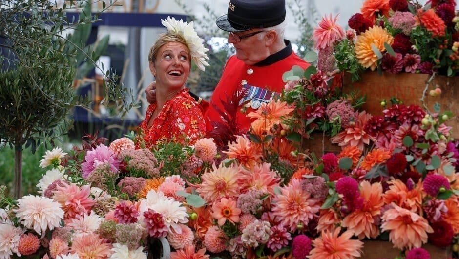 Exhibitor Andie McDowell poses with Chelsea Pensioner Peter Henry on the Dahlia Beach exhibit during press day at RHS Chelsea Flower Show 2021, Monday September 20, 2021. The show is being held, for the first time ever during autumn, in the wake of the COVID pandemic. Limited tickets are available for this one-off RHS show, which opens to the public Tuesday..