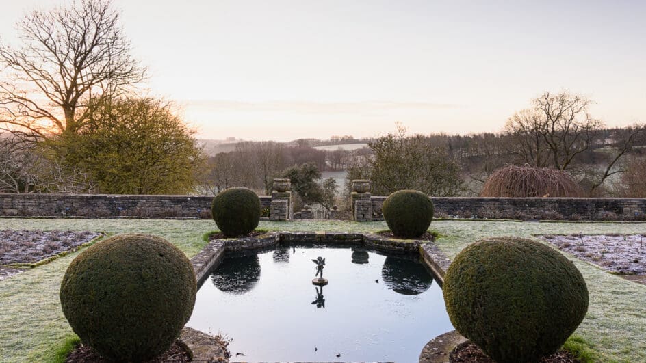 Formal lily pond on the Jewson Terrace at Cotswold Farm Gardens in February at Cotswold Farm, Gloucestershire