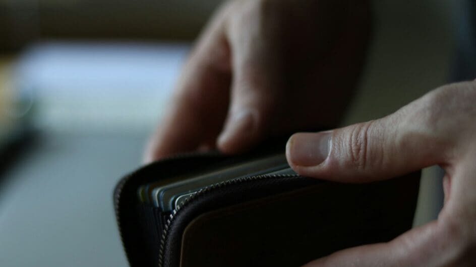 A person opening their wallet, preparing to pay