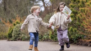 Children playing in RHS Gardens with the book entitled Guess How Much I Love You
