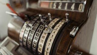 vintage cash register showing mechanical dials and levers.