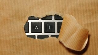 A piece of cardboard with keyboard buttons AI appearing through it